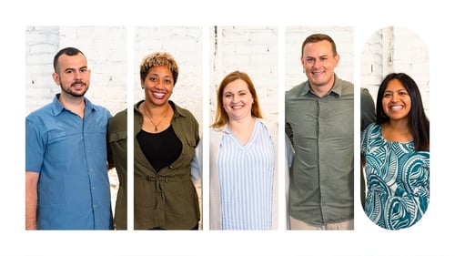 A group of employees posing together for a picture and smiling