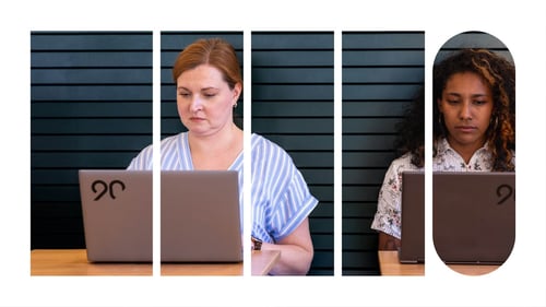 Two Ninety employees working on their laptops inside of a cafe